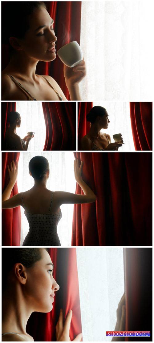 Woman with a cup of coffee by the window - Stock Photo